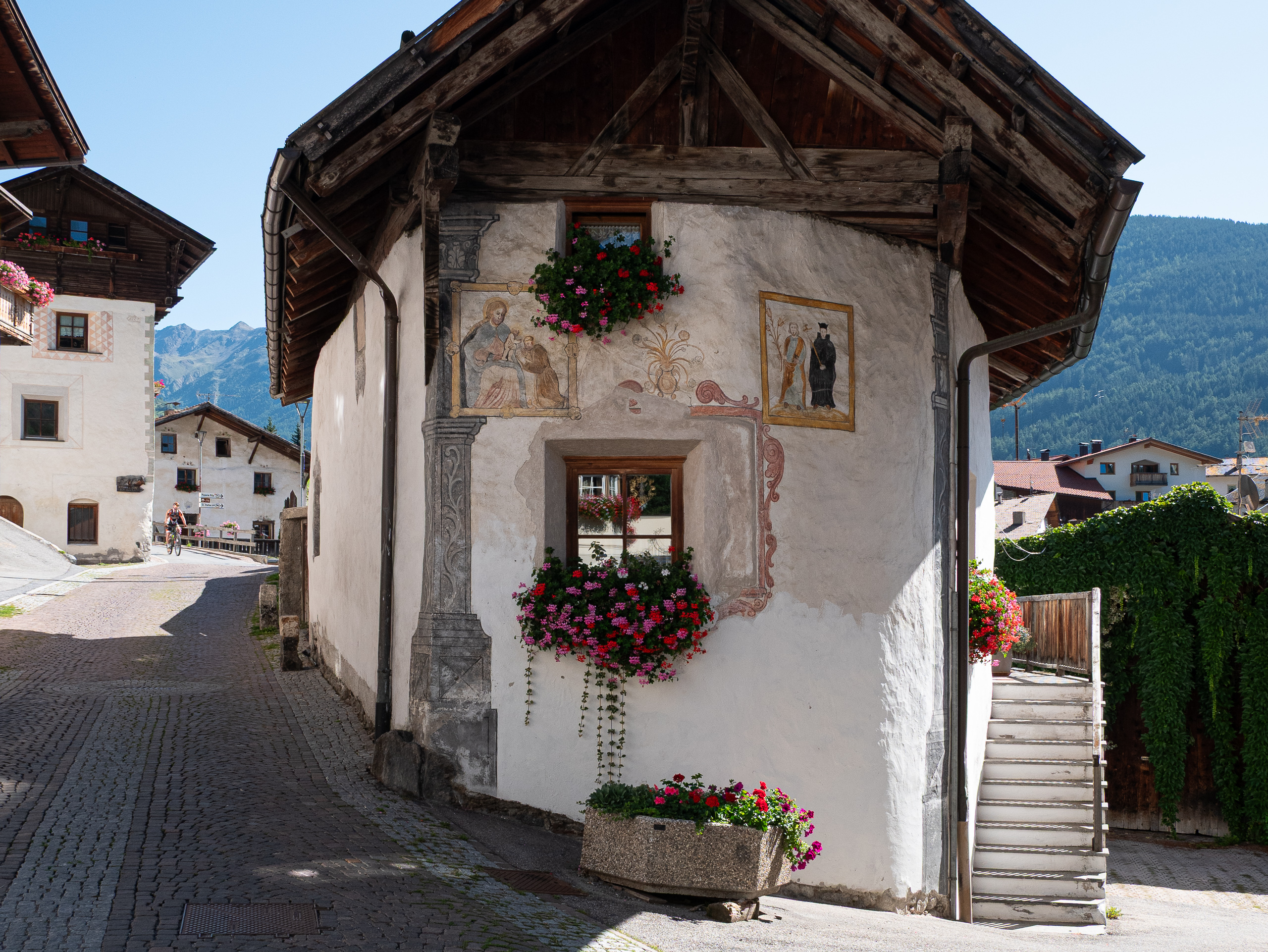 Freskengeschmücktes Südtiroler Haus mit Geranien im Dorf